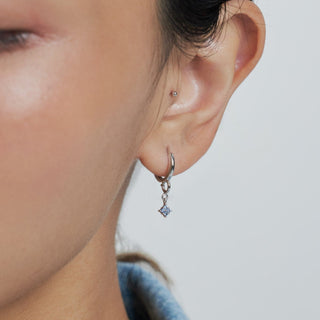 Alternative view of model wearing a solid charm paired with the hydrangea charm in blue sapphire and white gold